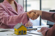 © amnaj - Businesswomen shaking hands after successful house purchase deal, closing a contract for new home