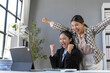 © amnaj - Two euphoric asian businesswomen celebrating a successful project or good news on a laptop in the office