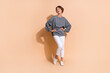 © deagreez - Full body photo of attractive young woman posing model look empty space dressed stylish gray clothes isolated on beige color background