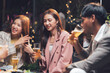 © Kritdanai - Nightlife Laughter: Friends Enjoying Drinks and Conversation at a Lively Outdoor Gathering