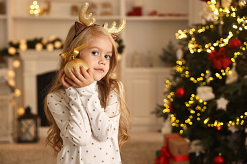 Wall Mural - Little girl with Christmas ornament at home, space for text