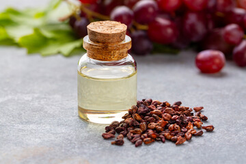 Wall Mural - Grape seed oil in small bottle and bunch of grapes together.