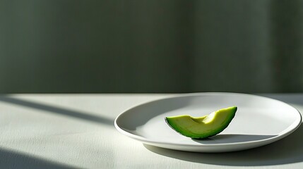 Wall Mural -   A white plate with an avocado cut in half rests on a white table near a window