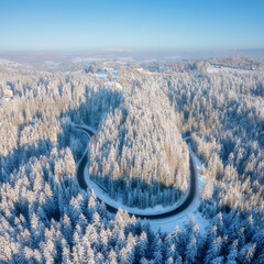 Wall Mural - aerial view on the curvy road and forest at the winter time. forest covered in snow. natural winter 