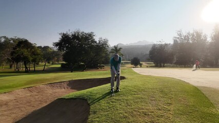 Wall Mural - man playing golf on beautiful course , swinging and hitting golf ball , luxury vacation