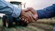 © Babb - Two men shake hands in front of a tractor