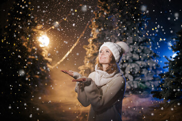 Woman Enjoying Snowy Night in Illuminated Forest