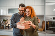 © Miljan Živković - young adult boyfriend surprise her girlfriend with gift box at home
