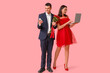 © Pixel-Shot - Young couple with mobile phone, laptop and bouquet of roses on pink background. Online dating