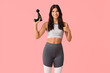 © Pixel-Shot - Sporty young woman with percussive massage device on pink background