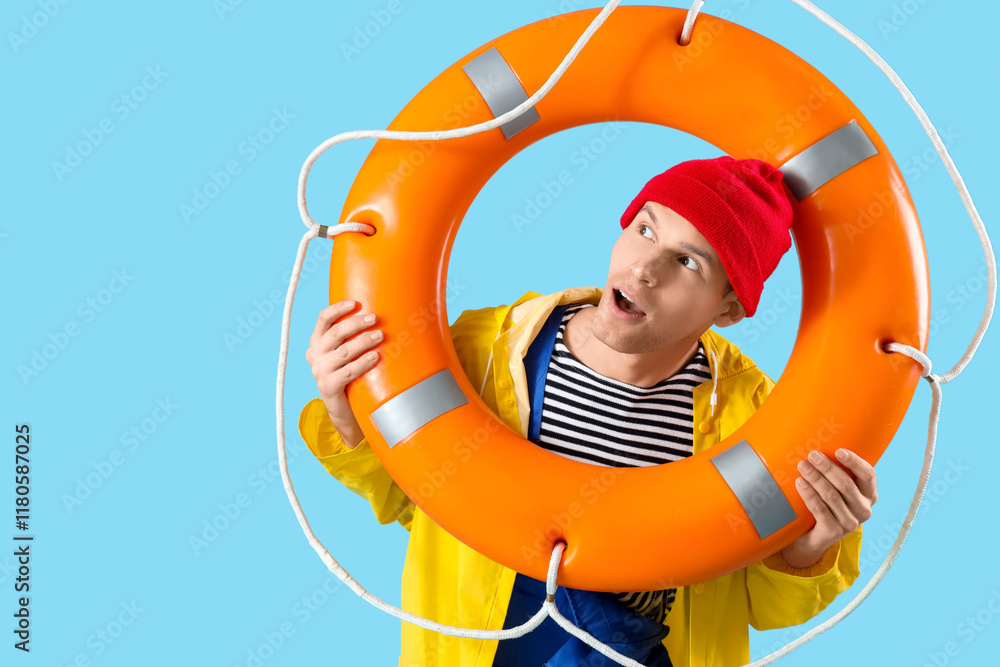 Shocked male sailor with rescue ring on blue background