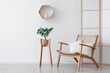 © Pixel-Shot - Interior of stylish living room with cozy wooden armchair, folding screen and houseplant