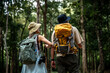 © APchanel - Hikers or explorers on journey carrying backpack, trekking poles looks into the distance observing and possibly guide trekking and trail exploration holiday ecotourism concept.