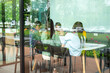 © Yingyaipumi - Side view of Group of creative young business team talking in conference room,view through the transparent glass wall.Modern business.Young focused business women and men working in conference room