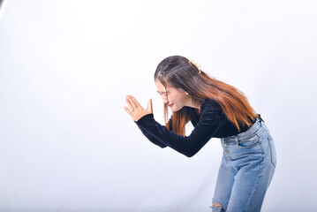 Wall Mural - A young Asian Woman in a Black Velvet Top and Denim Jeans making expressive gestures Isolated on white background