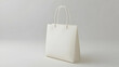 © visual artstock - Blank white paper shopping bag studio shot, neutral background, mockup for branding.