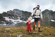 © EVERST - Father hiking with child in mountains family travel adventure vacations active healthy lifestyle outdoor, kid trekking using trekking poles and safety harness gear