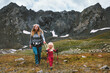 © EVERST - Mother hiking with child in mountains family travel adventure trip healthy lifestyle activity vacations outdoor, kid  using trekking poles and safety harness gear