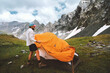 © EVERST - Man setting up tent camping gear in mountains hiking travel adventure outdoor, healthy lifestyle summer active vacations with climbing equipment