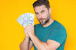 © Volodymyr - Man holding cash money in dollar banknotes on isolated yellow background. Studio portrait of business man with bunch of dollar banknotes. Dollar money concept. Career wealth business. Cash dollar.