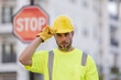 © Volodymyr - Man in worker uniform and hardhat with open hand doing stop sign with serious and confident expression, defense gesture. Serious builder with stop road sign. Builder with stop gesture, no hand.