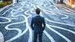 © jambulart - Businessperson stands, facing painted path choices.