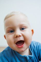 Wall Mural - Little one-year-old boy with different emotions on his face close-up. Emotional baby. Cheerful boy. Blue-eyed toddler boy.