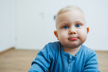 Little one-year-old boy with different emotions on his face close-up. Emotional baby. Cheerful boy. Blue-eyed toddler boy.