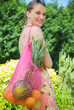 © fStop - Smiling young woman carrying a shopping bag full of fruit