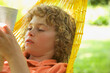 © fStop - Boy reading on a hammock