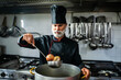 © Minerva Studio - Chef adding vegetables to broth in a professional kitchen