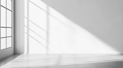 Poster - Sunlight streaming through a window, creating dramatic shadows on a blank wall and wooden floor in an empty room, providing a perfect backdrop for interior design concepts