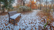 © bephoto - 初雪に包まれた公園のベンチと静かな小道