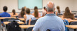© Bonsales - Bald senior professor sitting in a classroom full of high school or university students, attending a lesson