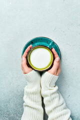 Wall Mural - cup of delicious matcha latte on light gray background, closeup. Top view.