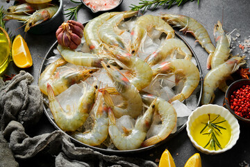 Wall Mural - Raw shrimps with lemon slices and rosemary on table, side view. Seafood.