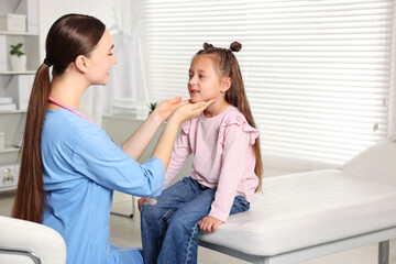 Wall Mural - Doctor examining girl's throat in clinic during appointment