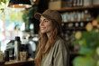 © StockUp - A cheerful young woman wearing a cap enjoys her time in a warm café, radiating happiness and comfort.