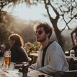 © StockUp - A young man in sunglasses relaxes at a cafe in warm sunlight.