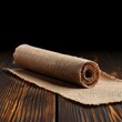 © Arnon  Parnnao - A rolled burlap fabric on a wooden surface, ideal for crafting and DIY projects.