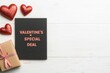 © Pixelbiz - Valentine's special deal sale banner concept. A festive Valentine's Day setup featuring a special deal card, a wrapped gift, and shimmering red hearts on a white wooden background.