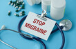 © Pawel - Tablet with text STOP MIGRAINE. Nearby is a tonometer, medicines, vitamins and a pen.
