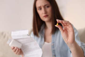 Wall Mural - Woman with pill and instruction, selective focus