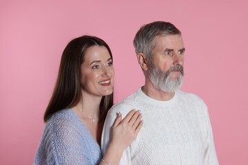 Wall Mural - Happy daughter and her father on pink background