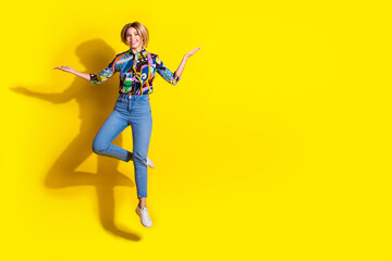 Wall Mural - Full length photo of lovely young lady jump hold empty space dressed stylish colorful garment isolated on yellow color background