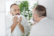 © auremar - a man is cleaning his face after shower