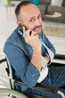 © auremar - man on wheelchair using his phone