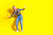 © deagreez - Full size photo of pretty young girl surfing have fun wear trendy colorful outfit isolated on yellow color background
