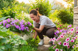 © Юлия Завалишина - Gardening and agriculture concept. Young woman farm worker gardening flowers in garden. Gardener planting flowers for bouquet. Summer gardening work. Girl gardening at home in backyard