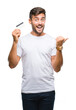 © Krakenimages.com - Young handsome man holding credit card over isolated background pointing and showing with thumb up to the side with happy face smiling